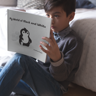 boy-reading-a-square-book-mockup-sitting-against-his-bed-a19163